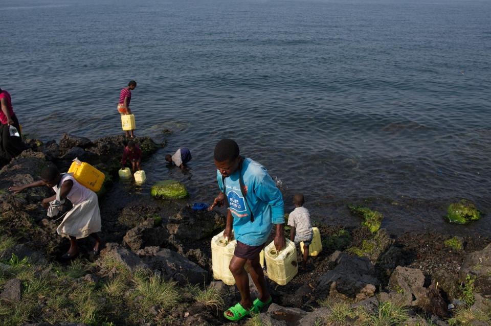 People fill jerrycans with water from Lake Kivu on the Himbi beach in Goma, in the east of the Democratic Republic of Congo on August 11, 2013 (AFP Photo/Phil Moore)