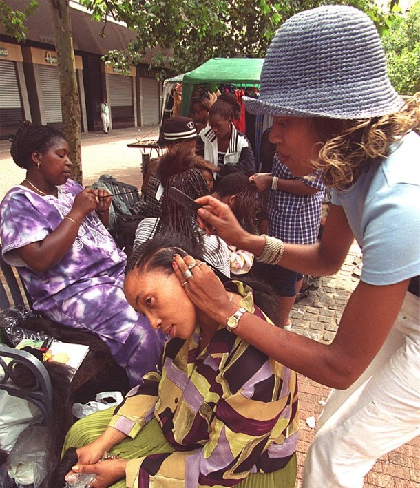 South African women getting their hair done, at a street in downtown Johannesburg. © AFP