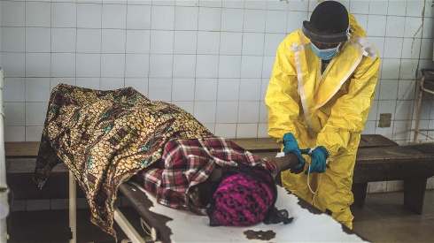 Photo: Tommy Trenchard/IRIN A health worker extracting blood to test a patient for Ebola