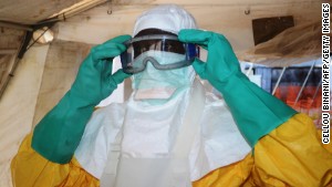 A picture taken on June 28, 2014 shows a member of Doctors Without Borders (MSF) putting on protective gear at the isolation ward of the Donka Hospital in Conakry, where people infected with the Ebola virus are being treated. The World Health Organization has warned that Ebola could spread beyond hard-hit Guinea, Liberia and Sierra Leone to neighbouring nations, but insisted that travel bans were not the answer. To date, there have been 635 cases of haemorrhagic fever in Guinea, Liberia and Sierra Leone, most confirmed as Ebola. A total of 399 people have died, 280 of them in Guinea. AFP PHOTO / CELLOU BINANICELLOU BINANI/AFP/Getty Images