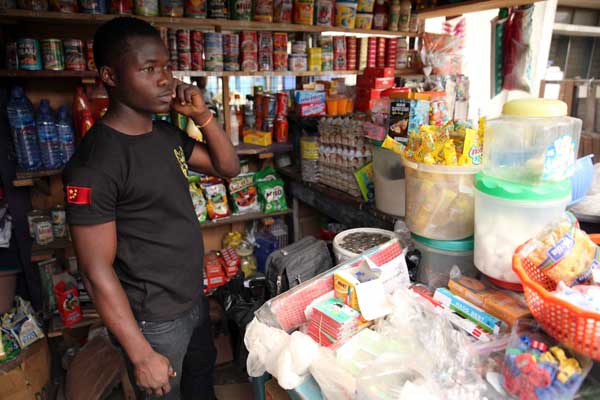 Kingsley Adukpo stands in his shop in Accra on February 11, 2014. Adukpo had to repeatedly raise his prices due to the weakening Cedi (Ghanaian currency). Ghana’s trade balance has worsened. The current account deficit has risen from an average of eight per cent of GDP before it started exporting oil to 13 per cent last year. AFP PHOTO | CHRIS STEIN