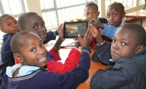 Photo: Julius Mwelu/Urban Gateway School children hold up one of the Samsung tablets used at the library.