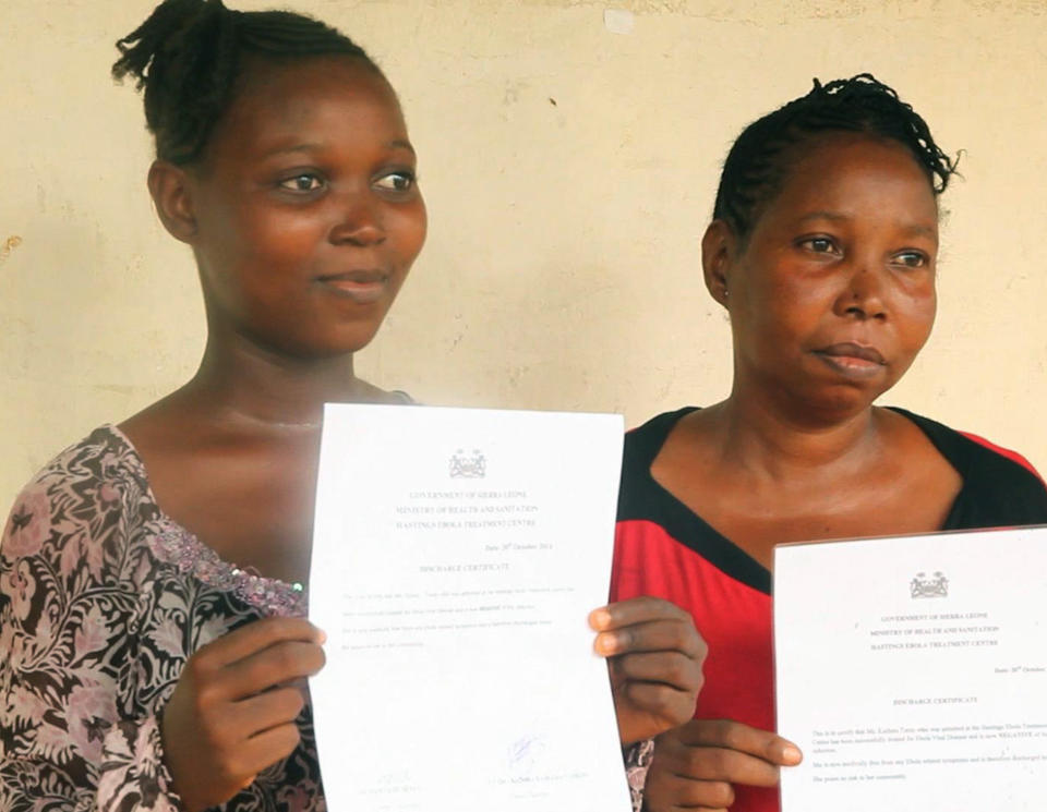 In this grab from video provided by Associated Press Television on Wednesday, Oct. 22, 2014, Ebola survivors Hawanatu Turay, left and an unidentified woman, display their certificates, after being given the all clear, at a treatment centre at Hastings, near Freetown, Sierra Leone. Dozens of Ebola survivors were discharged from a treatment center near Sierra Leone's capital on Wednesday and told they were virus-free. The third group released from the Hastings Treatment center, which included 45 patients, were also issued with health certificates they proudly held up. (AP Photo/Associated Press Television)