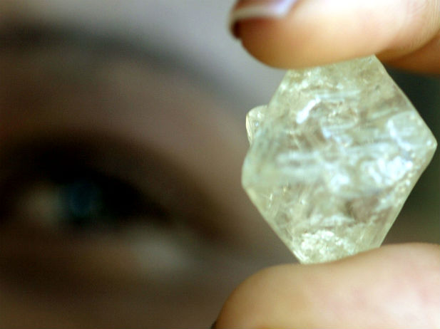A worker at the Botswana Diamond Valuing Company displays a rough diamond during the sorting process at the purpose-built centre in the capital Gaborone, August 26, 2004. (Juda Ngwenya/Courtesy Reuters)