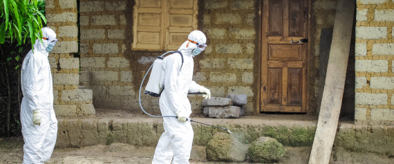 A healthcare worker in protective gear sprays disinfectant around the house of a person suspected to have Ebola virus in Port Loko Community, situated on the outskirts of Freetown, Sierra Leone, Tuesday, Oct. 21, 2014. | ASSOCIATED PRESS
