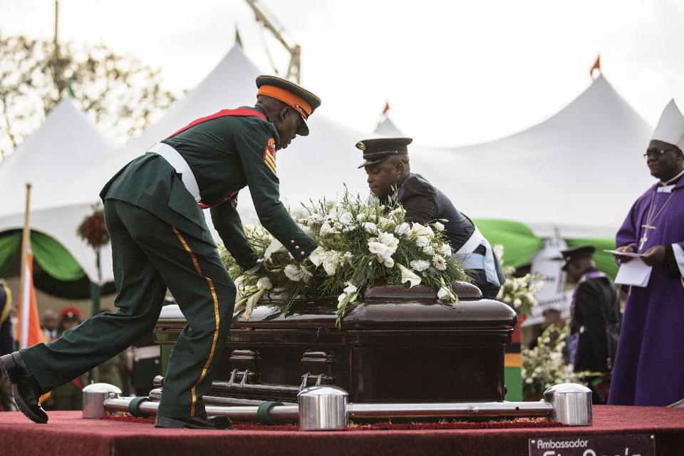 Zambian Armed Forces lay flowers on the casket of the late Zambian president ahead of lowering it into the grave during his state funeral on November 11, 2014 at Embassy Park in Lusaka (AFP Photo/Gianluigi Guercia)