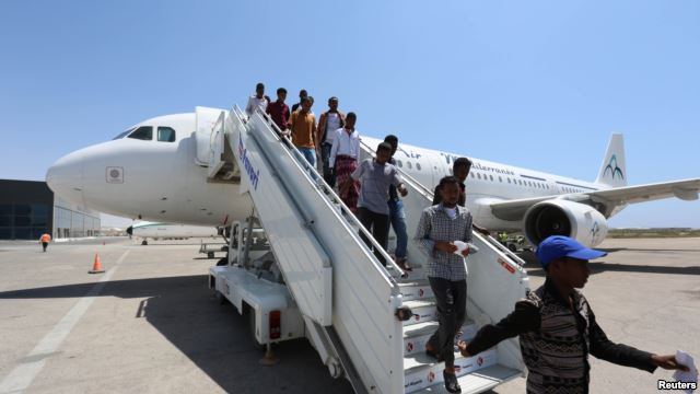 Daallo Airlines staff usher in passengers from Jeddah after their airline, Daallo Airlines operated by Air Mediterranee, arrived at the Aden Abdule International Airport in Somalia's capital Mogadishu, February 17, 2015.