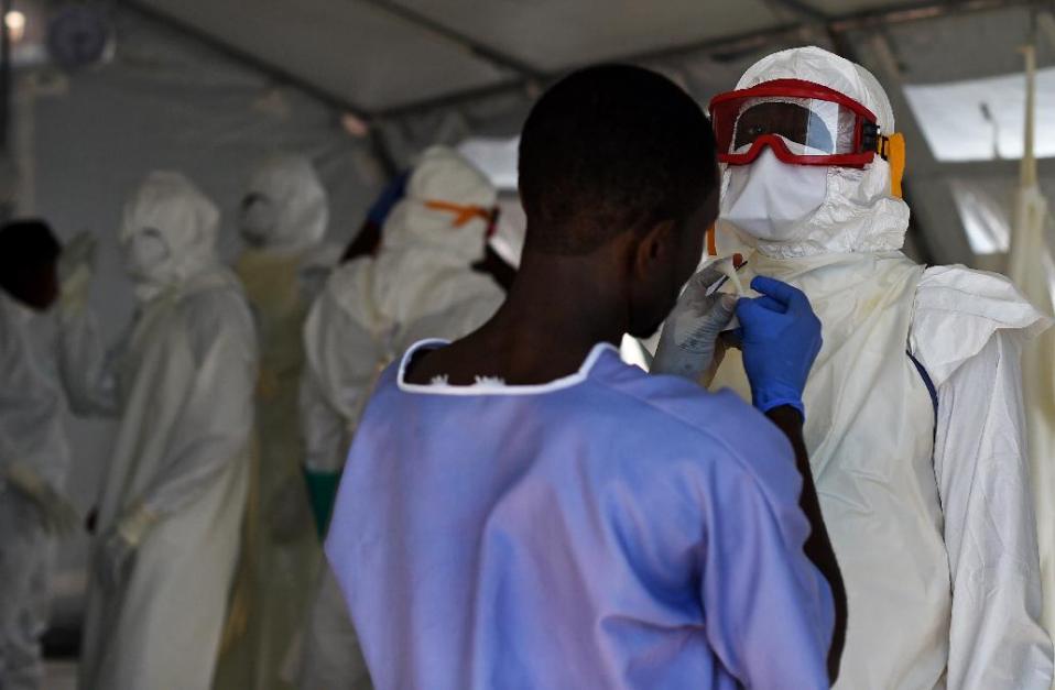 Health workers put on protective equipment at an Ebola treatment centre in Kenama, Sierra Leone, on November 15, 2014 (AFP Photo/Francisco Leong)