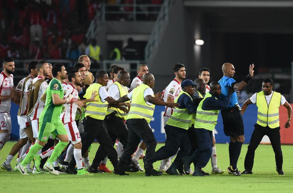 Security guards protect referee Rajindraparsad Seechurn (2nd-R) from Tunisia's players at the end of the 2015 African Cup of Nations quarter-final football match between Equatorial Guinea and Tunisia in Bata on January 31, 2015 (AFP Photo/Carl De Souza)