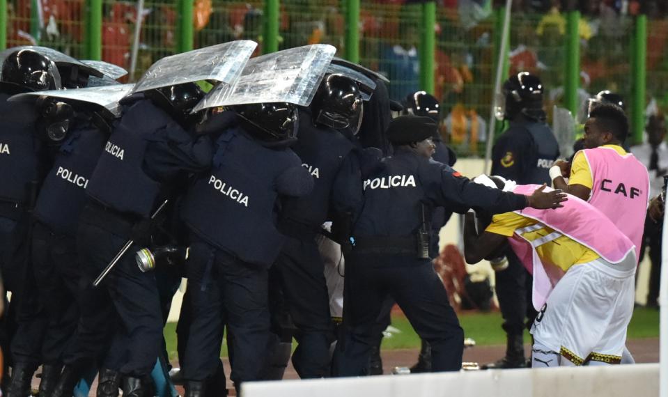 Ghana's national football team players leave the pitch protected by riot police at the half-time of the 2015 African Cup of Nations semi-final football match between Equatorial Guinea and Ghana in Malabo, on February 5, 2015 (AFP Photo/Issouf Sanogo)