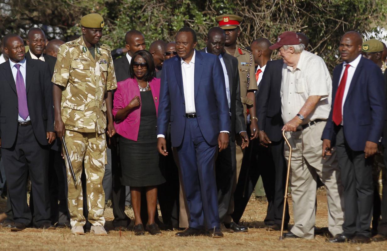 Kenya's President Uhuru Kenyatta (C) looks on as 15 tonnes of ivory confiscated from smugglers and poachers is burnt to mark the World Wildlife Day at the Nairobi National Park March 3, 2015. The United Nations on December 20, 2013, declared 3rd March World Wildlife Day as a celebration of wild fauna and flora and to raise awareness of illegal trade. The 2015 theme for World Wildlife Day is "Wildlife Crime is serious; let's get serious about wildlife crime". REUTERS/Thomas Mukoya (KENYA - Tags: SOCIETY CRIME LAW POLITICS ANNIVERSARY ENVIRONMENT ANIMALS)