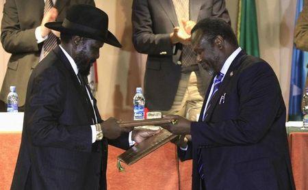 South Sudan's President Salva Kiir (L) and South Sudan's rebel commander Riek Machar exchange documents after signing a ceasefire agreement during the Inter Governmental Authority on Development (IGAD) Summit on the case of South Sudan in Ethiopia's capital Addis Ababa, Feburary 1, 2015. REUTERS/Tiksa Negeri