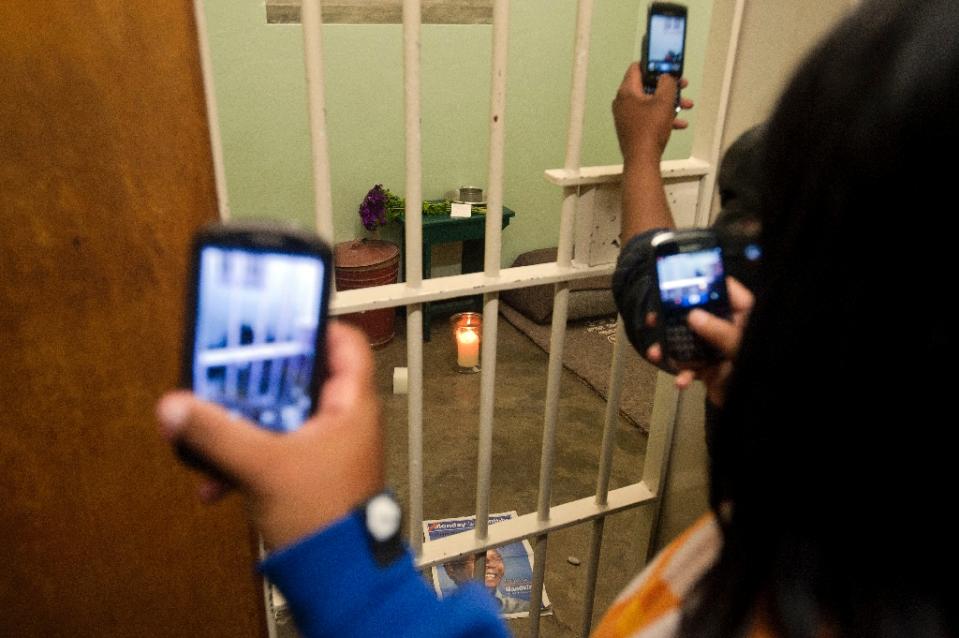 People take pictures of Nelson Mandela's former cell at Robben Island on December 13 2013 (AFP Photo/Rodger Bosch)