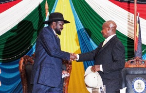 President Salva Kiir (left) shakes hands with Uganda's President Yoweri Museveni (right) after signing a peace agreement in Juba, on August 26, 2015 (AFP Photo/Charles Lomodong)