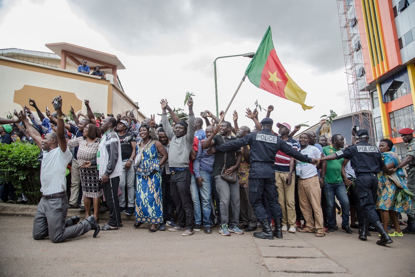 Hundreds of supporters raise their arms and wave the national flag while waiting to greet the Cameroonian opposition leader Maurice Kamto in Yaoundé on Oct. 5, the day of his release from prison. STRINGER/AFP via Getty Images