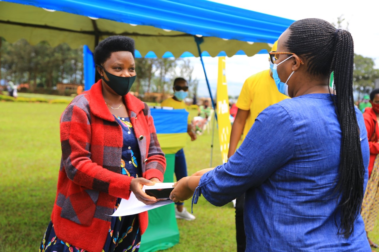 Minister for agriculture Dr. Gerardine Mukeshimana hands a smart phone to one of rural women during the event on Tuesday.