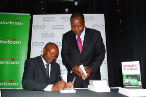 Dr. Tonny Omwansa signing the book for ICT Cabinet Secretary Dr. Fred Matiang’i