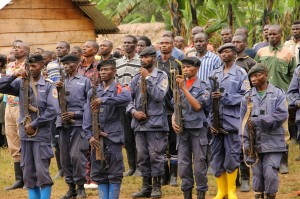 Congolese national police officers in front of the 83 Democratic Forces for the Liberation of Rwanda guerrillas who surrendered in Kigogo. SARAH FLUCK FOR THE NEW YORK TIMES