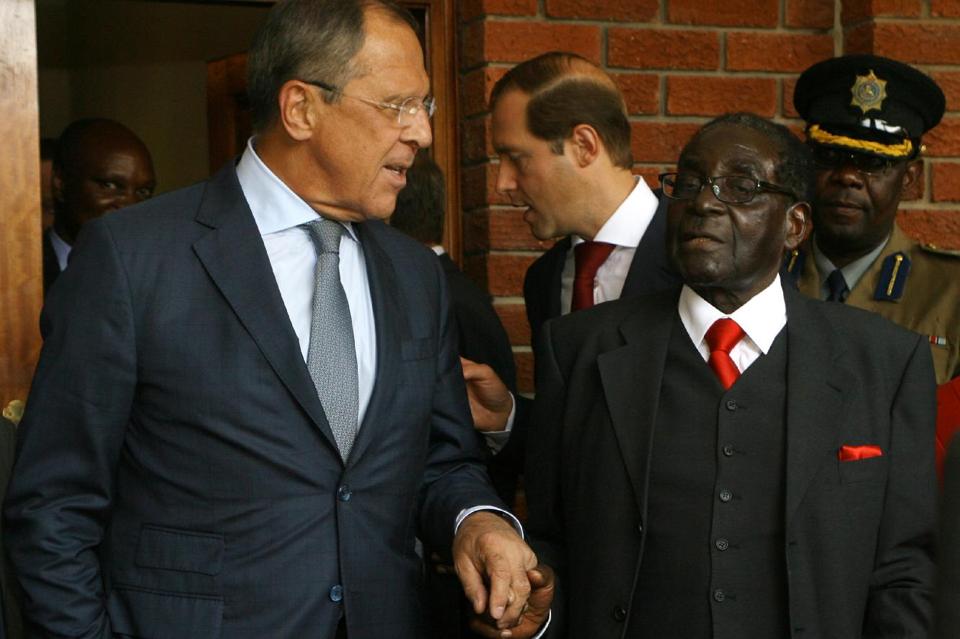 Russian Foreign Minister Sergei Lavrov (L) and Zimbabwean President Robert Mugabe shake hands after a meeting in Zvimba, Zimbabwe, on September 16, 2014 (AFP Photo/Jekesai Njikizana)