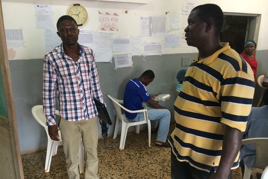 Dr. J. Soka Moses, left, in the Ebola treatment unit he runs at JFK hospital in Monrovia, Liberia. Dr. Moses is the Ebola unit's only doctor. Patrick McGroarty for The Wall Street Journal