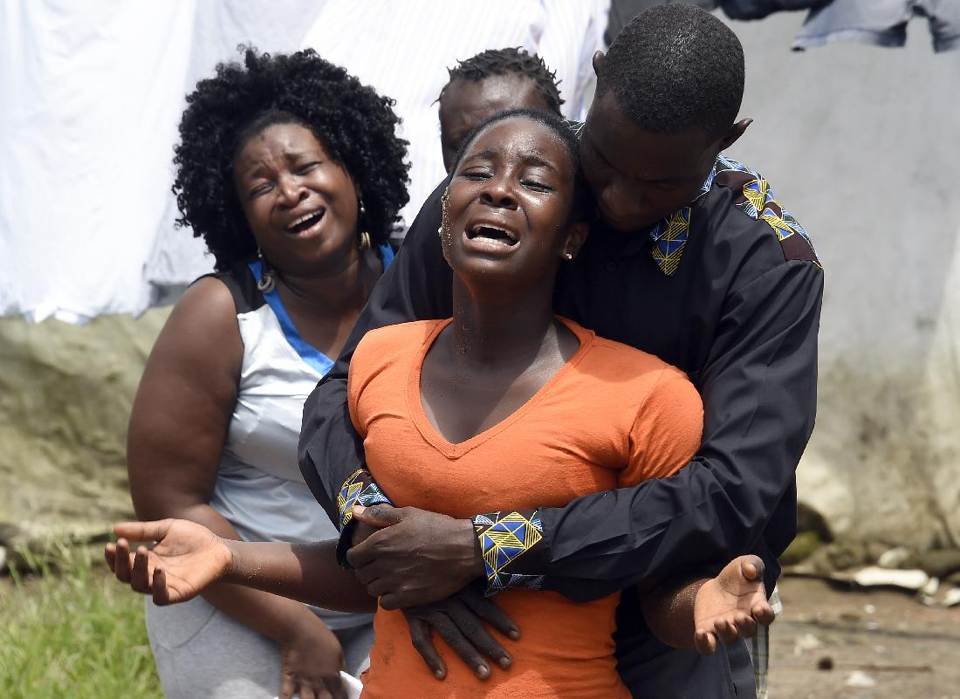 A woman (C) reacts after her husband is suspected of dying from the Ebola virus, in the Liberian capital Monrovia, on October 4, 2014 (AFP Photo/Pascal Guyot)