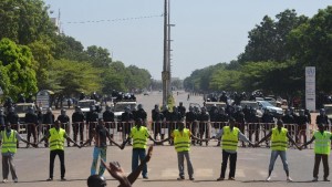 Police hold hands as they cordon off access to the parliament on October 29, 2014 in Ouagadougou, during a demonstration (AFP Photo/Issouf Sanogo)