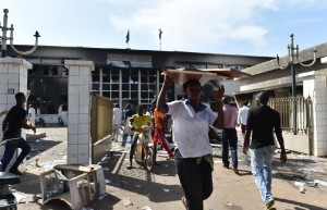 People loot on October 31, 2014 what is salvageable inside the burnt parliament in Ouagadougou a day after it was stormed by protesters (AFP Photo/Issouf Sanogo)