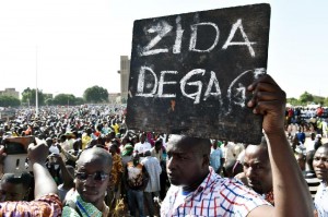 A man holds up a placard that reads in French, "Zida get out", referring to Isaac Zida, a high-ranking officer named by the military to lead the country's transition, during a protest in Ouagadougou on November 2, 2014 (AFP Photo/Issouf Sanogo)