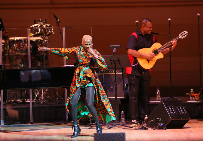 Angelique Kidjo performing with Dominic James on guitar at Carnegie Hall. Credit Ruby Washington/The New York Times