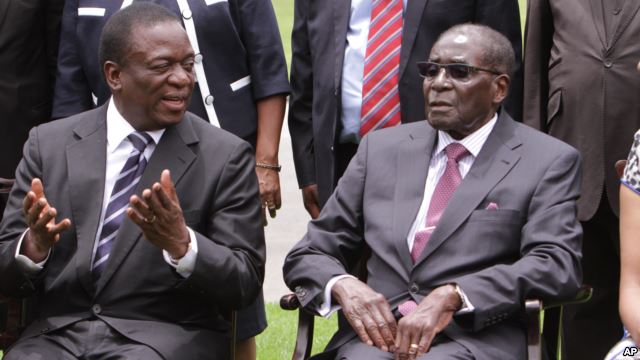 Emmerson Mnangagwa, left, Vice President of Zimbabwe chats with Zimbabwean President Robert Mugabe after the swearing in ceremony at State House in Harare, Dec, 12, 2014.