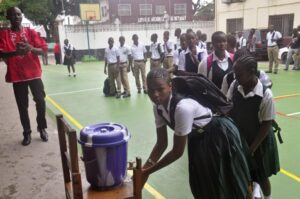 Liberian school children wash their hands before entering their classrooms as part of the Ebola prevention measures at Cathedral High School as students arrive in the morning to attend class in Monrovia, Liberia, Monday, Feb. 16, 2015. Students in Liberia began returning to the classroom Monday after a six-month closure during the Ebola epidemic that left thousands dead in this West African country.(AP Photo/Abbas Dulleh) 