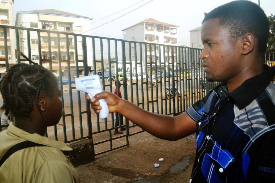 A Guinean student gets her temperature checked on January 19, 2015 outside the Oumou Diaby school in Conakry (AFP Photo/Cellou Binani)