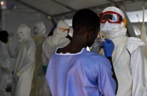 Health workers put on protective equipment at an Ebola treatment centre in Kenama, Sierra Leone, on November 15, 2014 (AFP Photo/Francisco Leong) 