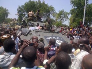 Maiduguri residents welcome troops who recovered an armored personnel carrier (APC) from Boko Haram insurgents in Konduga on September 16, 2014 (AFP Photo/Tunji Omirin) 