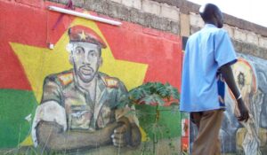 A man walks past a painting featuring military captain Thomas Sankara (L) in Ouagadougou on November 18, 2010 (AFP Photo/Ahmed Ouoba) 