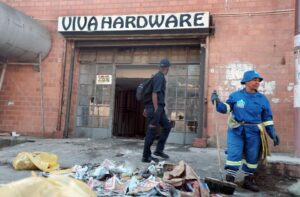 A worker from the eThekwini municipality cleans up after a xenophobic attack on a Somali businesses in Umlazi township, south of Durban, on April 10, 2015 (AFP Photo/Rajesh Jantilal) 