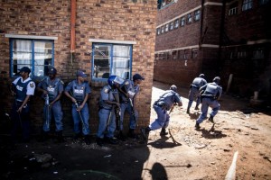 South African anti-riot policemen raid a hostel in Benoni, outside Johannesburg, on April 16, 2015, whose local residents have been protesting against the presence of Foreign-owned shops in the area (AFP Photo/Marco Longari)