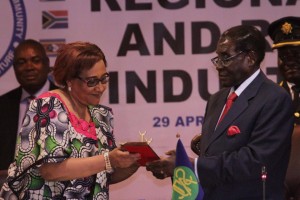 Zimbabwean President Robert Mugabe, right, hands over a ceremonial key to SADC Excecutive Secretary Stergomena Lawrence Tax during the official opening of the Southern African Development Community(SADC) Heads of State and Government Extraordinary Summit on Industrialisation in Harare, Wednesday, April, 29, 2015. The summit was called by heads of state in an effort to craft a strategy for industrialisation in the region through value addition and beneficiation of abundant natural resources in Africa. (AP Photo/Tsvangirayi Mukwazhi)