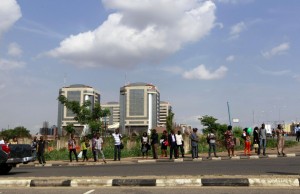 People wait at a bus stop, as fuel scarcities persist in Abuja, Nigeria May 25, 2015. Chronic fuel shortages in Nigeria brought phone firms, banks and flights to a standstill on Monday, just four days before Muhammadu Buhari's inauguration as president of Africa's biggest economy and top oil exporter. REUTERS/Afolabi Sotunde