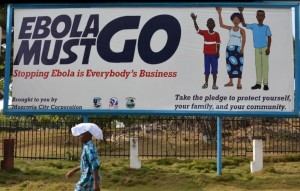 A man walks past an ebola campaign banner with the new slogan 'Ebola Must GO' in Monrovia on February 23, 2015 (AFP Photo/Zoom Dosso)