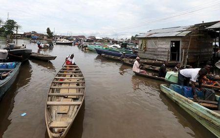 People ride in canoes and speedboats at Swali jetty near the banks of the Nun River on the outskirts of the Bayelsa state capital, Yenagoa, in Nigeria's delta region October 8, 2015. REUTERS/Akintunde Akinleye