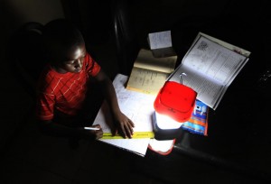 In this photo taken Wednesday Sept. 2015, a student does his homework using a solar lantern in Harare, Zimbabwe. The normal rains did not fall, which caused water levels to drop in dams that produce electricity, so local people and businesses across Zimbabwe and Zambia are suffering power black-outs for up to 48-hours at a time. Some traditional chiefs blame an angry river god, but the government blames the lack of rain, and work to expand the Kariba power station will not be complete for at least three years, said Partson Mbiriri, permanent secretary in Zimbabwe’s ministry of energy and power development. (AP Photo/Tsvangirayi Mukwazhi)