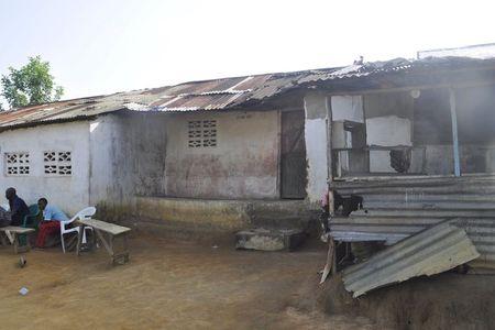 File photo of men sitting in front of a house where Ebola victim Nathan Gbotoe lived, in Paynesville, Liberia, November 24, 2015. REUTERS/James Giahyue