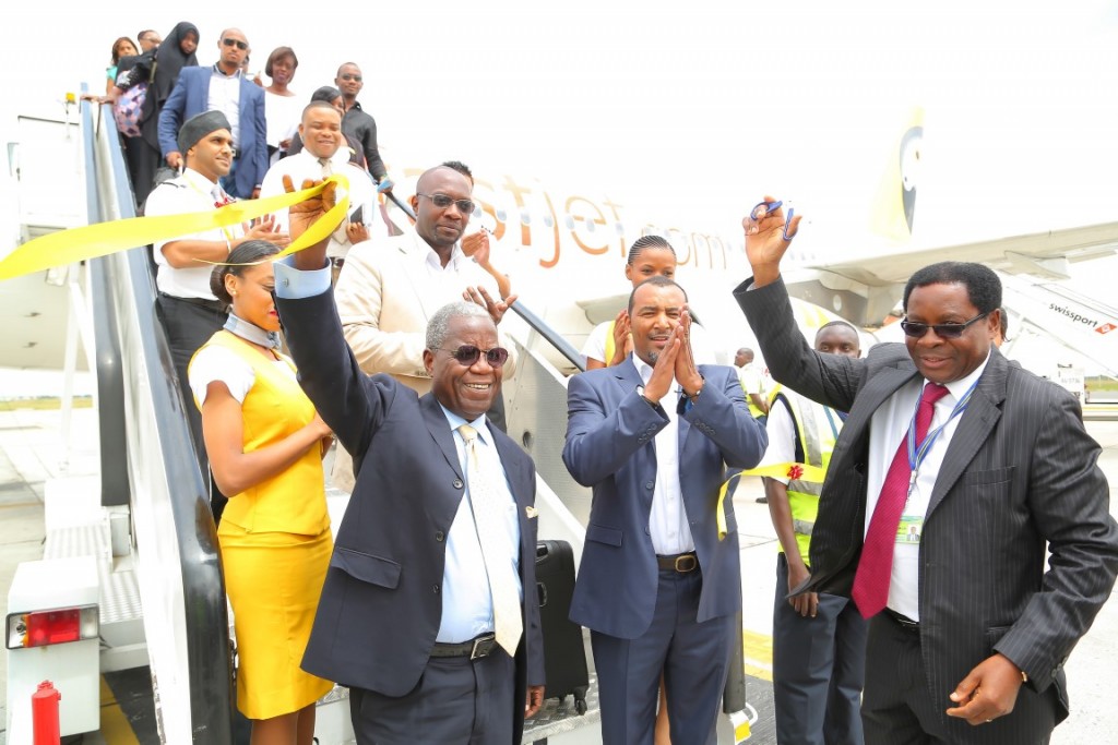 Ribbon cutting: High Commissioner of the United Republic of Tanzania John Michael Haule (right) cuts a ribbon on touch down at Jomo Kenyatta International Airport to officially launch fastjet Tanzania’s first route to Kenya. fastjet General Manager for East Africa, Jimmy Kibati (centre) and Director of fastjet Tanzania, Ami Mpungwe (left) join the cabin crew and passengers to celebrate the occasion.