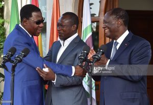 Former Beninese president Thomas Yayi Boni (L) embraces Benin's newly elected President Patrice Talon next to Ivory Coast's President Alassane Ouattara following a reconciliation meeting between the two Beninese leaders at the presidential residence in Abidjan on April 18, 2016. / AFP / ISSOUF April 18, 2016| Credit: ISSOUF SANOGO