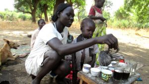 A woman makes coffee outdoors in South Sudan. A new partnership aims to build on the progress of revitalizing the country’s fledgeling coffee industry. Photo by: Amy the Nurse / CC BY-NC-ND